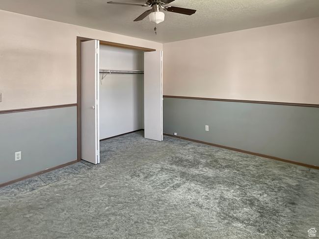 Unfurnished bedroom with carpet, a closet, baseboards, and a ceiling fan | Image 19