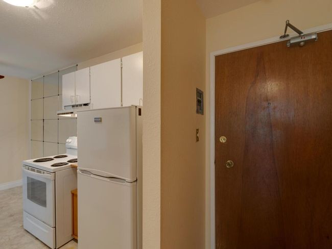 Kitchen with white appliances, white cabinets, and under cabinet range hood | Image 15
