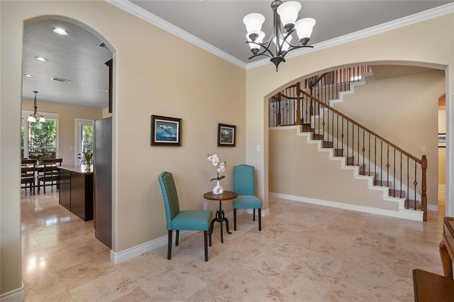 Dining room used as a music room with distinguished travertine flooring, crown moldings and elegant lighting fixtures. | Image 8