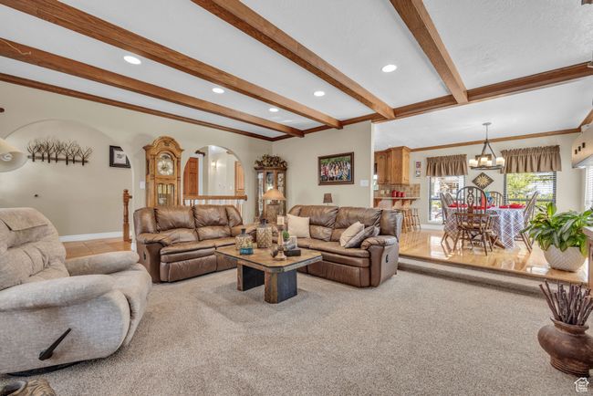 Living area featuring arched walkways, beamed ceiling, a chandelier, recessed lighting, and crown molding | Image 8