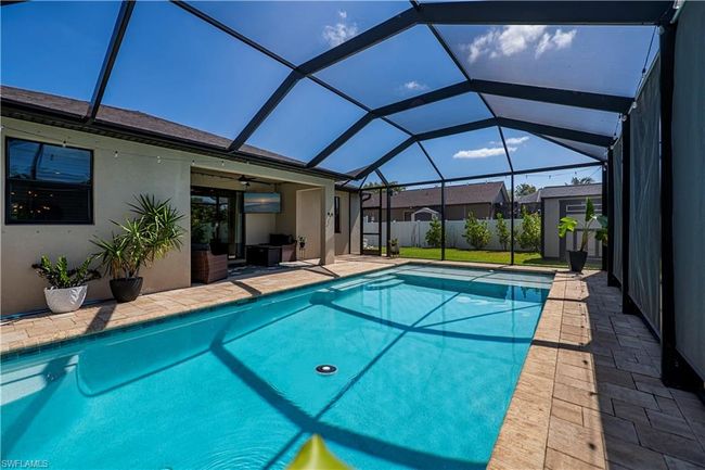 View of swimming pool featuring a patio, a ceiling fan, glass enclosure, and a fenced in pool | Image 22
