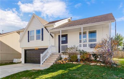 View of front of home with a porch, a garage, and a front lawn | Image 2