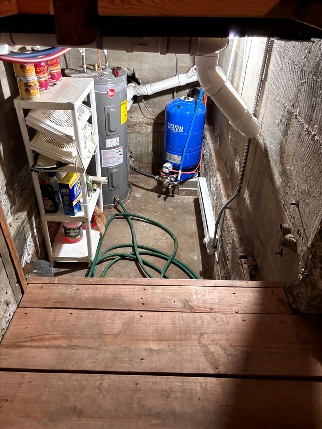 Detailed view of electric water heater, a water pressure tank, and concrete flooring | Image 23