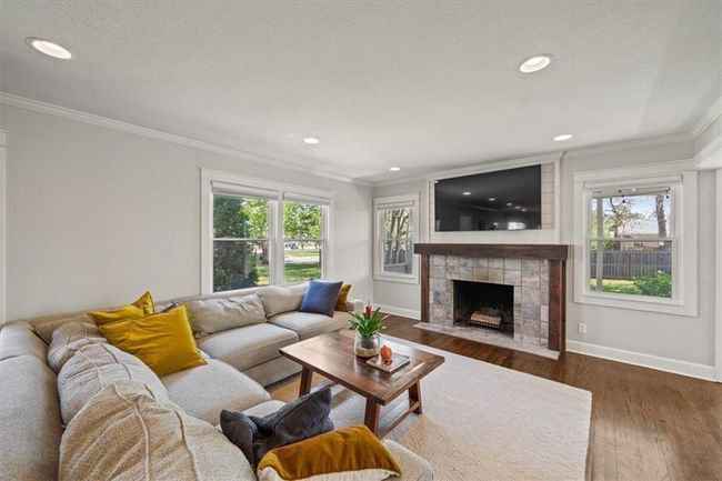 Living area featuring ornamental molding, baseboards, wood finished floors, and a healthy amount of sunlight | Image 4