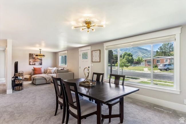 Dining space featuring a chandelier, carpet, healthy amount of natural light, and a mountain view | Image 10