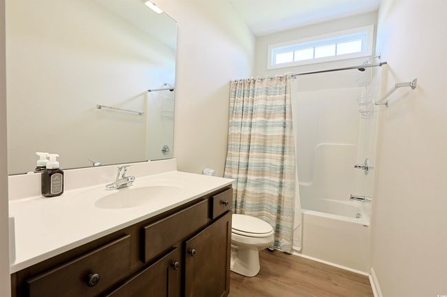 Full bath featuring vanity, shower / tub combo with curtain, and wood finished floors | Image 21