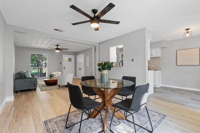 Dining area with a ceiling fan, light wood-type flooring, and a textured ceiling | Image 11
