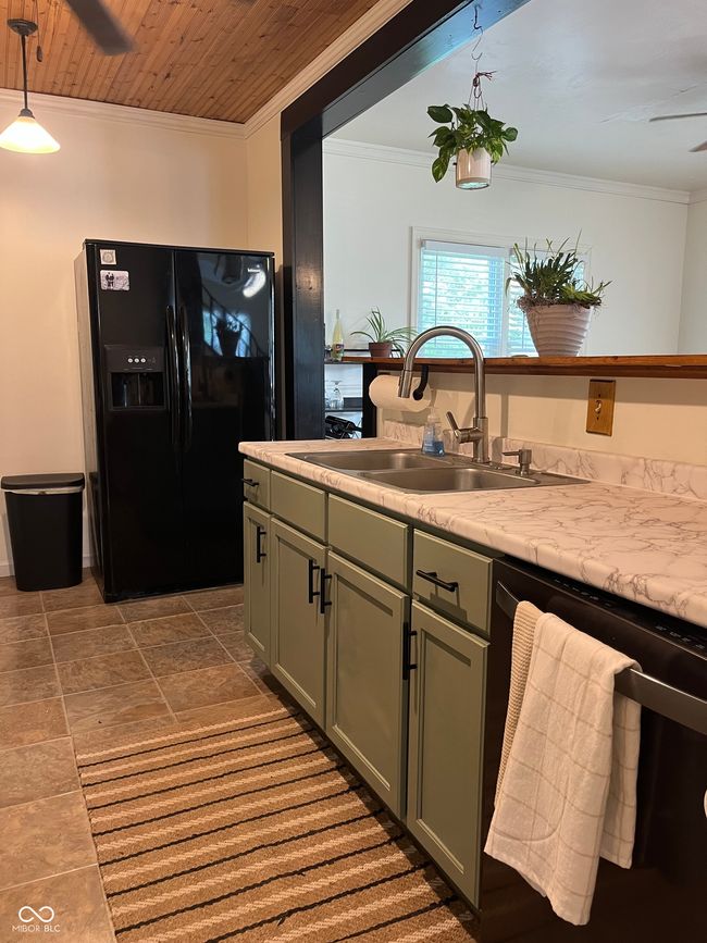 kitchen featuring black refrigerator with ice dispenser, dishwashing machine, a sink, light countertops, and ceiling fan | Image 15