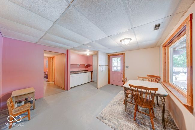 dining space featuring a paneled ceiling and concrete flooring | Image 21