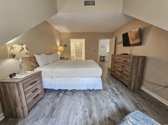 Bedroom with baseboards, dark wood finished floors, and ensuite bath | Image 23