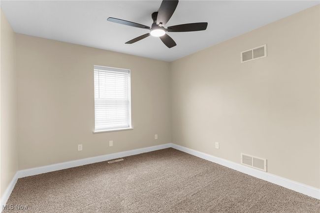 Carpeted spare room featuring ceiling fan and baseboards | Image 15