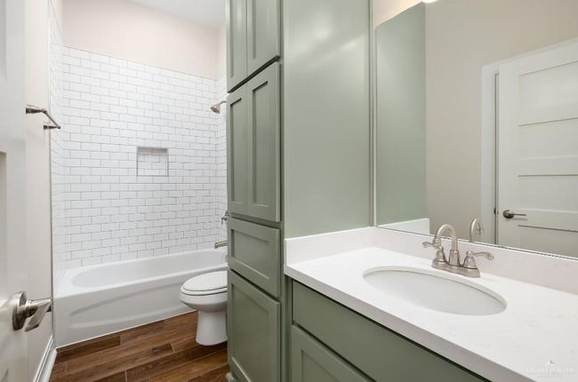 Bathroom featuring toilet, shower / washtub combination, vanity, and wood finished floors | Image 17