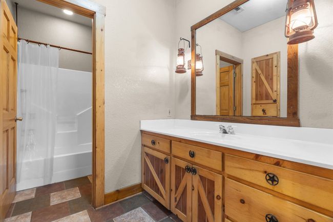 Bathroom with stone tile flooring, baseboards, vanity, and visible vents | Image 30