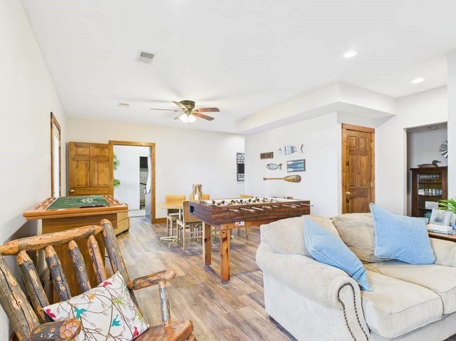 Lower level family room with wood floors, recessed lighting, visible vents, and ceiling fan | Image 50