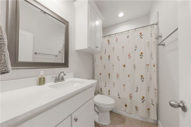 Bathroom featuring vanity, a shower with curtain, and tile patterned flooring | Image 11