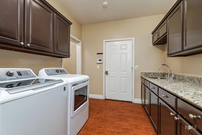 utility rm w/ granite countertops, sink, and a | Image 41