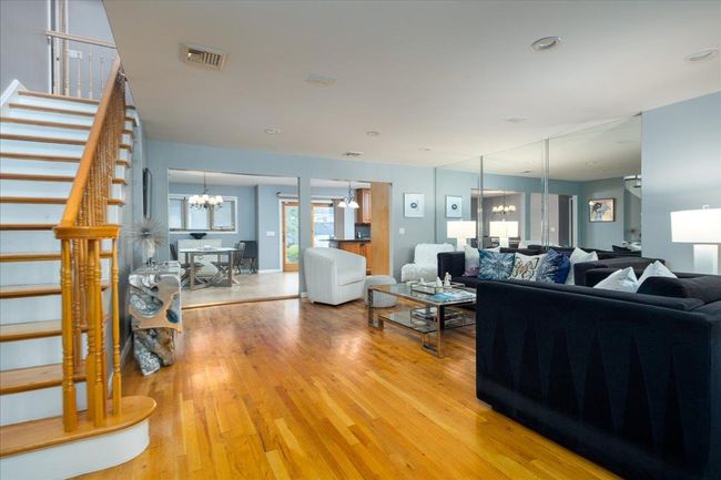 Living area featuring a chandelier, stairs, and light wood-style flooring | Image 4