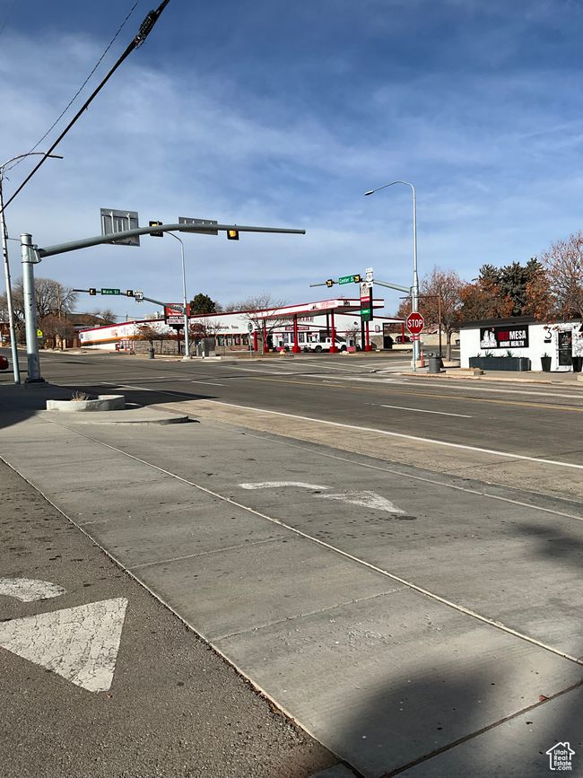 View of road featuring traffic lights, traffic signs, and sidewalks | Image 4