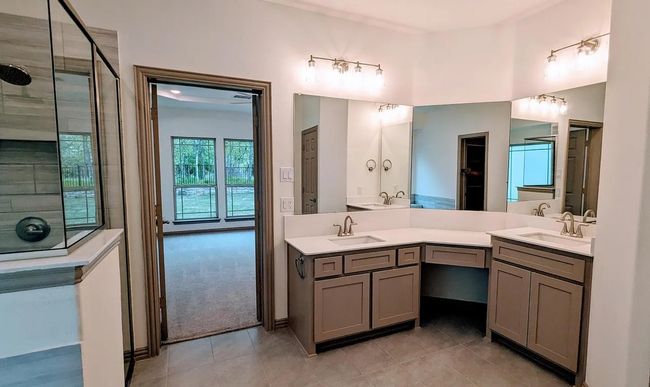 Bathroom with tile patterned floors, a sink, double vanity, and a tile shower | Image 18