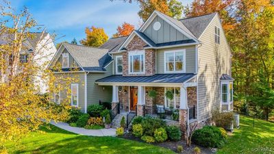 An elongated sidewalk leads you to a full front porch with stunning stacked stone accents and a custom front door | Image 3