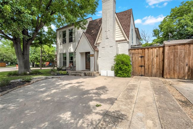 Tudor home with roof with shingles, a chimney, and brick siding | Image 39