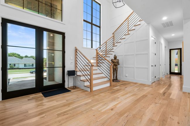Entrance foyer featuring french doors, stairway, wood finished floors, healthy amount of natural light, and a towering ceiling | Image 5