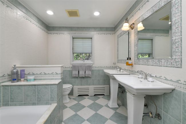 Full bathroom with toilet, tile walls, ornamental molding, and a healthy amount of sunlight | Image 16