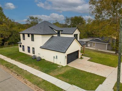 View of side of property featuring central AC unit, a yard, and a garage | Image 2