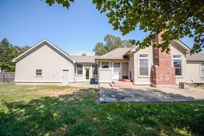 Rear view of house with a lawn and a patio area | Image 2