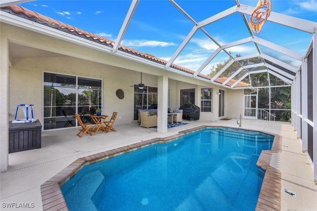 View of pool featuring ceiling fan, a patio, glass enclosure, and area for grilling | Image 21