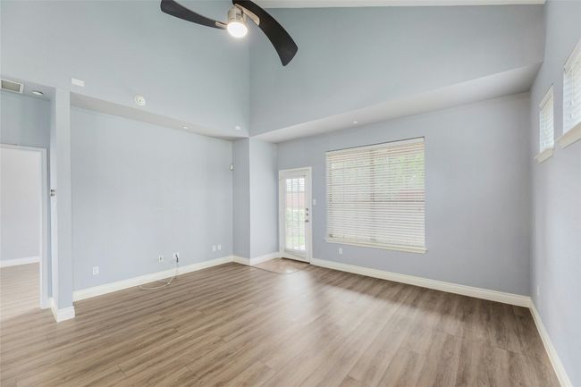Spare room with a ceiling fan, light wood-type flooring, high vaulted ceiling, and recessed lighting | Image 7