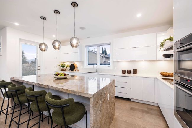 Kitchen with a sink, modern cabinets, and white cabinets | Image 9