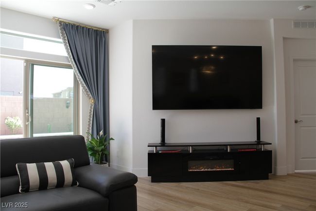 Living area with visible vents, light wood-style flooring, and baseboards | Image 12