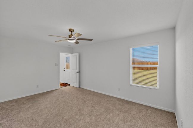 Carpeted empty room with a ceiling fan and baseboards | Image 16