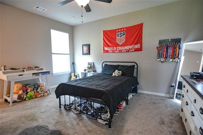 Bedroom with ceiling fan and carpet flooring | Image 26