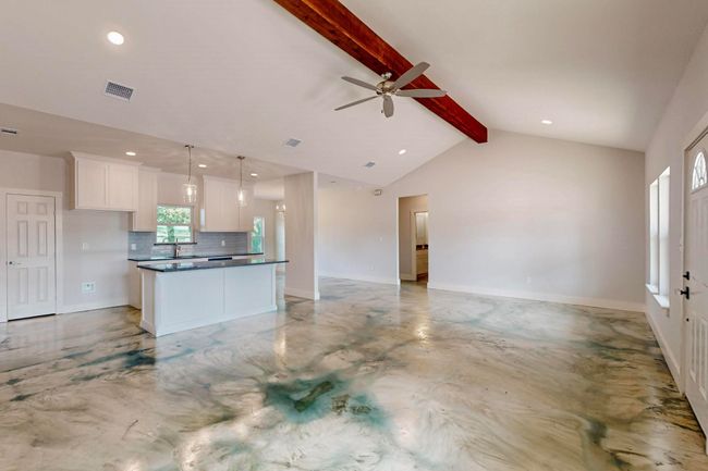 Unfurnished living room featuring concrete flooring, ceiling fan, and recessed lighting | Image 19