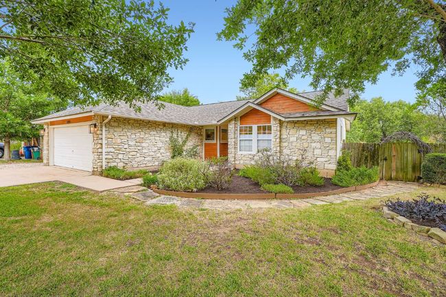 View of front of property with stone siding, an attached garage, a shingled roof, and driveway | Image 4