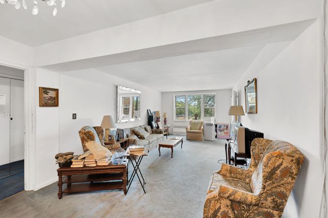 Living area with light carpet and radiator | Image 14