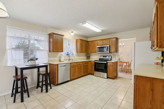 Kitchen featuring a sink, light countertops, brown cabinets, and appliances with stainless steel finishes | Image 9