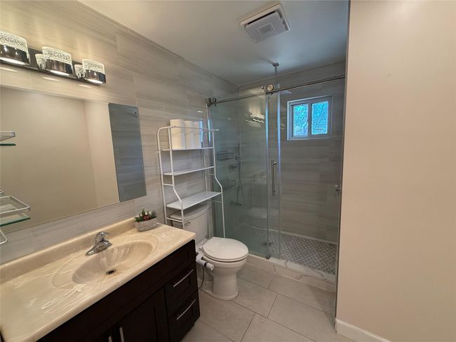 Full bath with toilet, a stall shower, visible vents, tile patterned flooring, and vanity | Image 7
