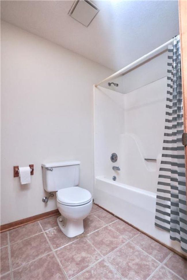 Bathroom featuring shower / bathtub combination with curtain and tile patterned flooring | Image 32