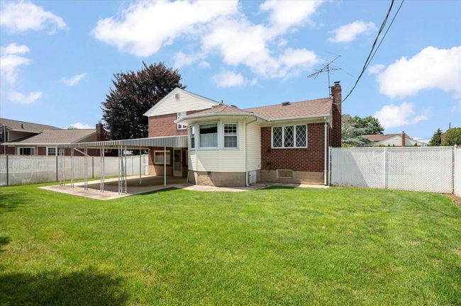 Back of house featuring a patio, a chimney, a fenced backyard, and brick siding | Image 24