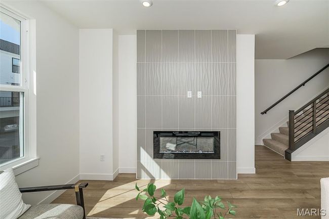 Living room with a glass covered fireplace, recessed lighting, stairway, and wood finished floors | Image 15