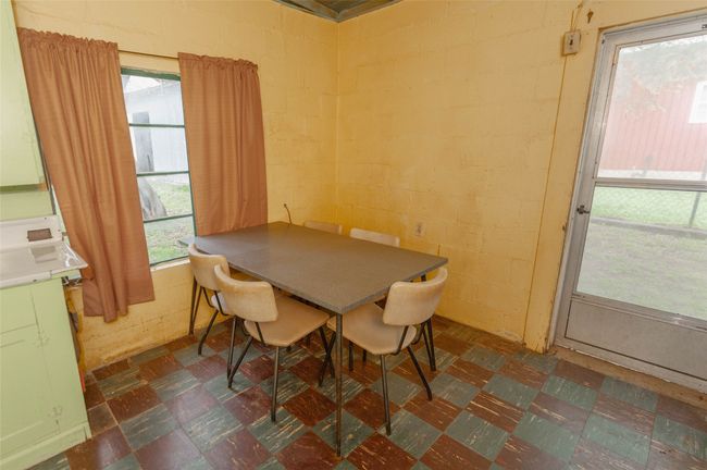 Dining area featuring dark floors and concrete block wall | Image 25