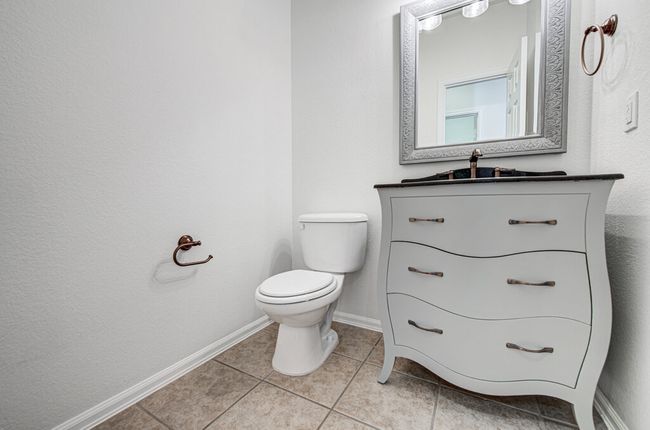 Half bath featuring tile patterned flooring, toilet, vanity, and baseboards | Image 17