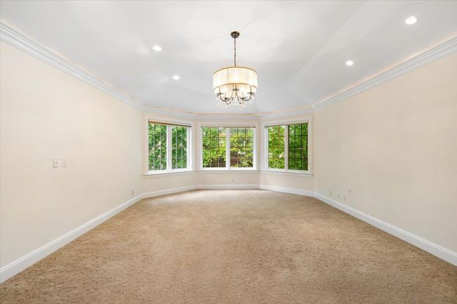 Unfurnished room with ornamental molding, plenty of natural light, a chandelier, light colored carpet, and baseboards | Image 16