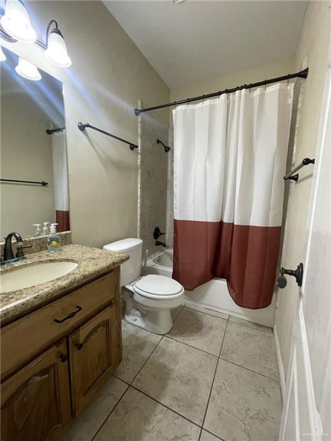 Full bath with vanity, shower / bathtub combination with curtain, and tile patterned floors | Image 12
