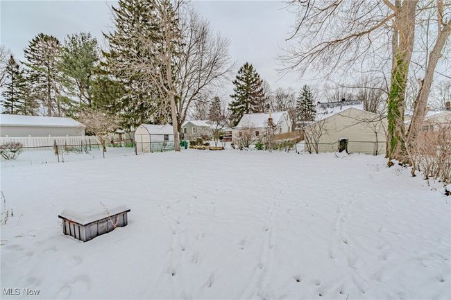 Yard layered in snow with an outbuilding | Image 11