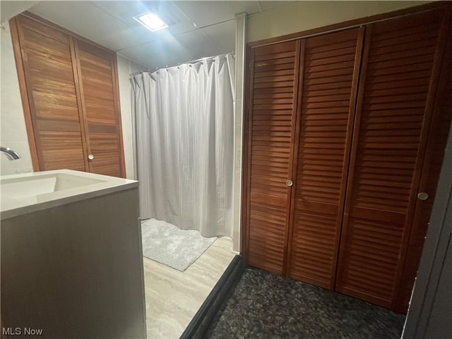 walk in shower featuring dark hardwood / wood-style floors and sink | Image 23