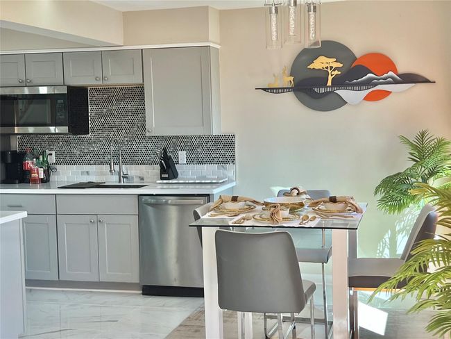 Kitchen featuring light countertops, a sink, appliances with stainless steel finishes, and gray cabinets | Image 20